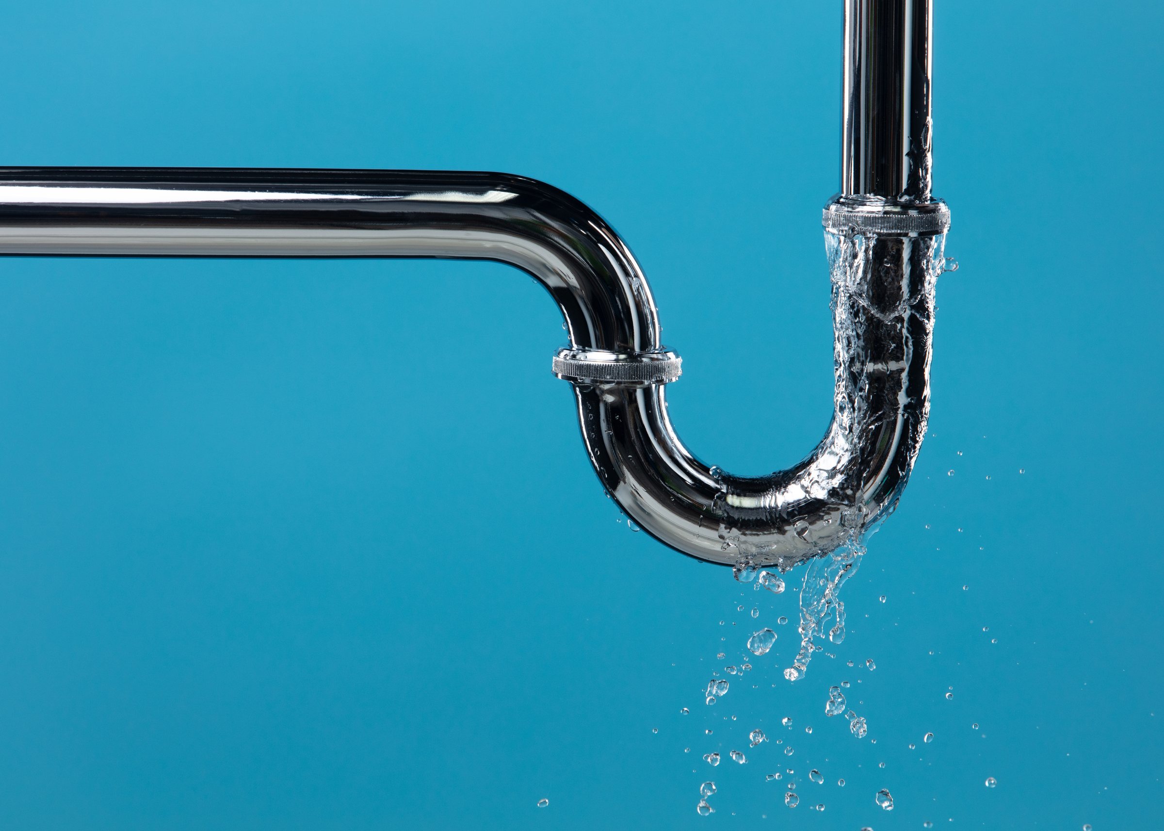 Leaking chrome plumbing pipe against a blue background